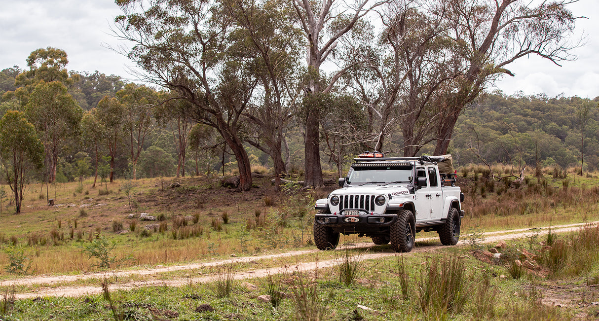 Jeep Gladiator mit Pioneer Platform und Backbone im Outback unterwegs. Eine Batwing von Rhino Rack ist seitlich montiert.